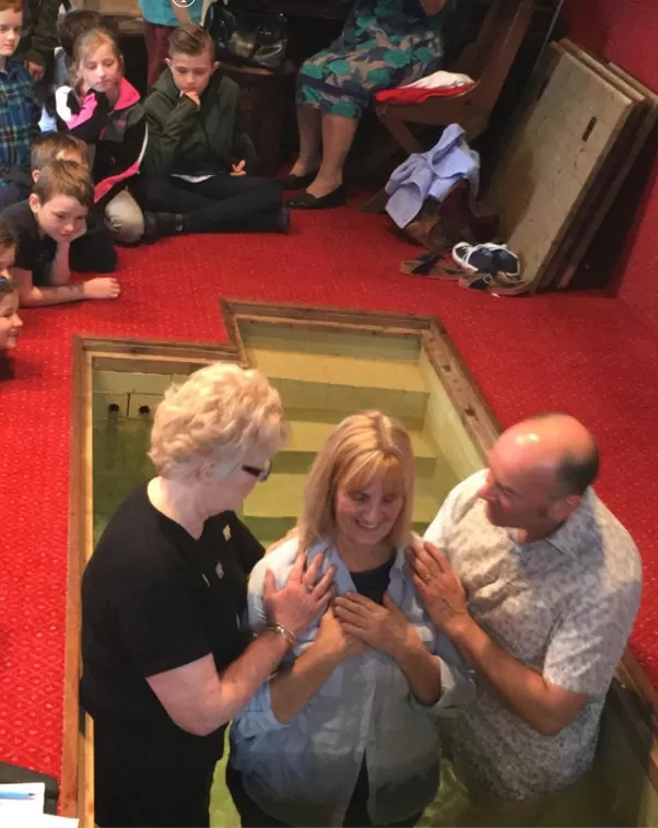 Woman being baptised indoors at Stocksfield Baptist Church