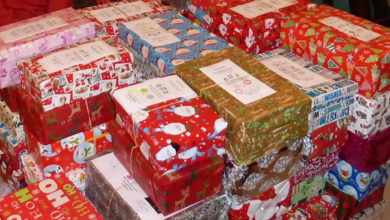 large pile of shoeboxes wrapped in Christmas wrapping paper